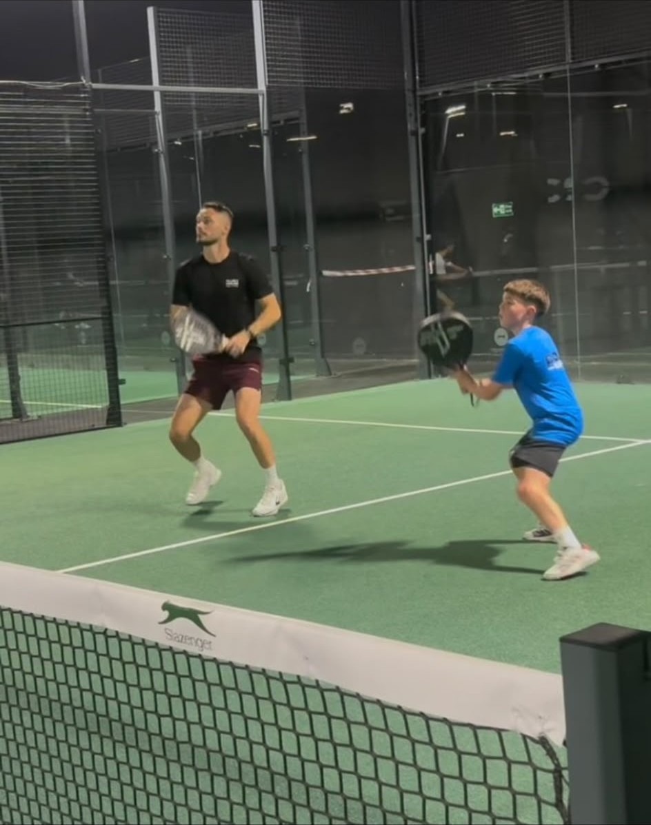 Marcus coaching a junior player on a padel court